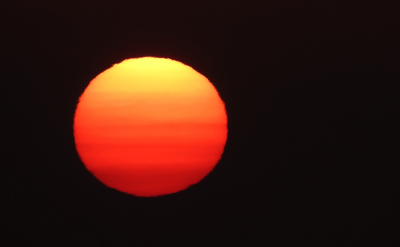 De zon begon als een wazig streepje. De kleuren en de vorm groeiden aan.
Zo werd die.