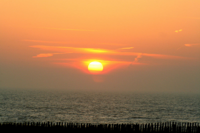 deze foto is gemaakt toen de zon onderging, het was wat vochtig en dat geeft de foto met wat mist boven de zee.