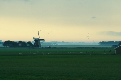 Lekker bij de zonsopkomst een typische NLomgeving.Molens zowel de oude als nieuwe versie en de uitgestrektheid van de Friese omgeving