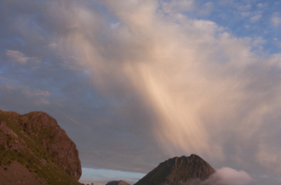 de foto is genomen in de avond. De wolken trokken op. Er ontstond een spel tussen de bergen, wolken en het licht.
