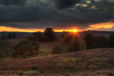 Zonsondergang op de Veluwezoom. Foto is gemaakt vanaf een wandelpad. Voor deze compositie gekozen waarbij heuvellijnen en de bomen het beeld afwisselen.