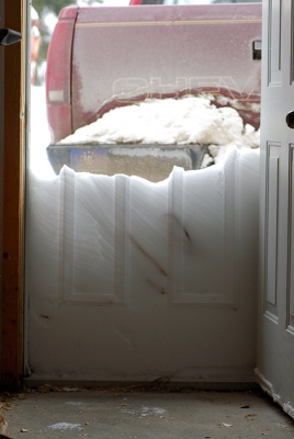 De wind heeft flink gewaaid en er is behoorlijk wat sneeuw tegen de garagedeur opgestapeld laagje voor laagje.