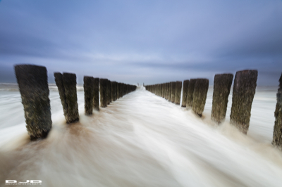 Van een laag standpunt in het water met behulp van de zelfontspanner. Doordat het statief in het water staat is de scherpte wat verloren gegaan (bewegingsonscherpte). 
Op de dag zelf was het overwegend bewolkt weer (grijze lucht) ten tijde van de foto kwam de zon nog een beetje door waardoor er een beetje blauw in de lucht kwam.
