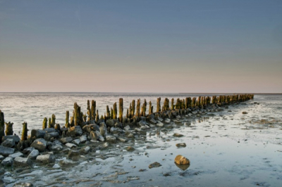 Zonsondergang Waddenzee bij Moddergat. Tijdstip 20:18 uur.  Object (steen) op voorgrond in beeld genomen om diepte in de foto te krijgen.
