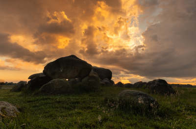 Bij zonsondergang aan het eind van een dag met stevige buien hunebed D 15 vanuit een laag standpunt gefotografeerd