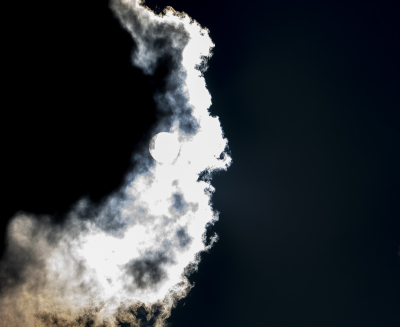 Nee geen blimsemschicht bij heldere avondhemel. Het idee achter deze foto was om op licht bewolkte dag het lichtspel tussen zon en wolken vast te leggen waarbij de randen van de wolken verlicht worden door de zon die erachter schijnt. Hier het moment waarop de zon precies achter de wolken vandaan komt. Een voorwaarde hier voor een goede foto was om de contouren van de zon te laten zien en die van de wolken ervoor. Slechts een paar foto's gemaakt voordat het licht te fel werd.