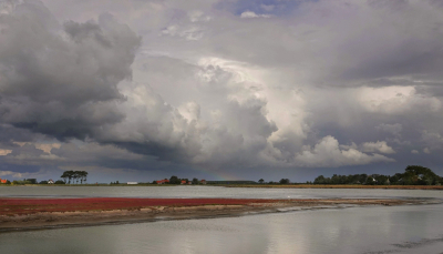 De laatste dagen prachtige wolkenluchten boven een rood kleurend landschap.