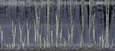 Andere bewerking van een foto van een sluisje in Zeeland.
Hierbij heb ik het neerstortende water gesoleerd en de foto omgedraaid. Een wat vervreemdend beeld van een berkenbos is het resultaat.