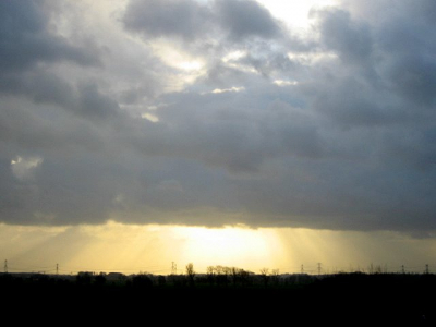 dalende zon achter laaghangende bewolking geeft stralend effect.