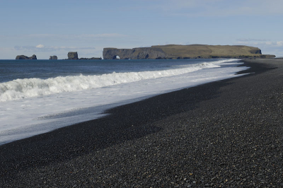 Geen spectaculaire foto, maar wel een mooie plek. Als je je omdraait bij de eerdergeplaatste basaltformaties is dit het uitzicht. Een gitzwart lavastrand met in de verte Dyrholaey. Een bekende zeevogelkolonie die overigens gesloten is gedurende het broedseizoen. De telkens terugtrekkende golven gaven wel een leuk patroon op het strand.

Nikon D2X, AF-S 17-55/2.8