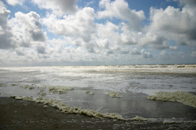 opboxend tegen de wind op het strand, vreselijk m'n best doen om camera tegen het stuivende zand te beschermen