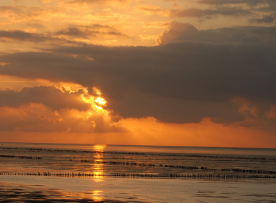 De foto is genomen van af de dijk. De zon kwam net weer te voorschijn van achter de wolken.