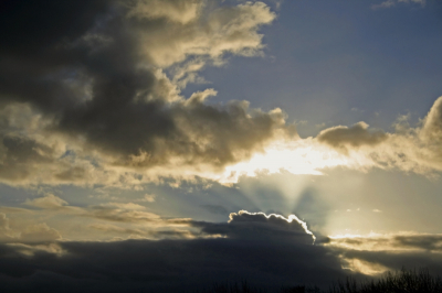Vanaf een duin zag ik dat de zon 'worstelde' met de donkere wolken. En kreeg ik zowaar het schouwspel van een zonneharp cadeau.