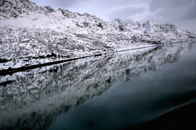 Opzettelijk scheef. Soms is het wel eens lekker om van de conventie af te wijken om iets nieuws te proberen.
Door de opzettelijk scheve horizon kon ik de lengte van de bergen in een verdwijnpunt laten lopen, dat net buiten de foto ligt. De boeggolf rechtsonder versterkt  de lijn.